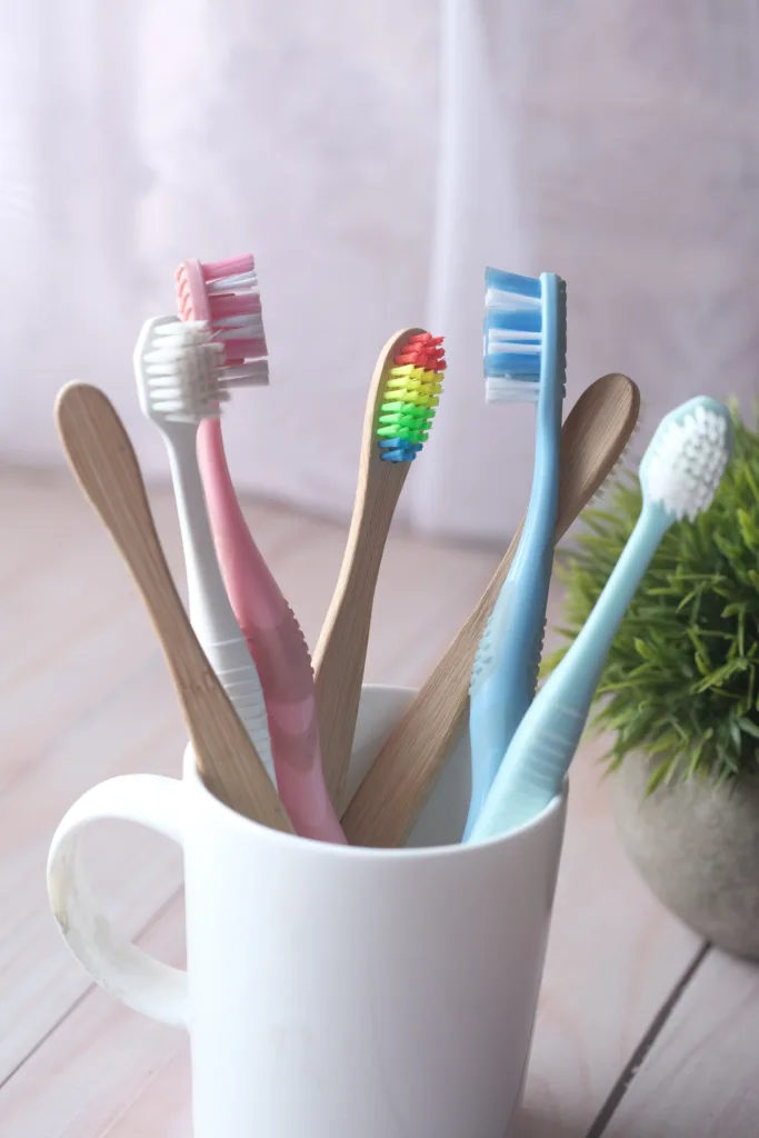 7 colorful toothbrushes in a white cup sitting on the bathroom counter, Kids Smiles Pediatric Dentistry