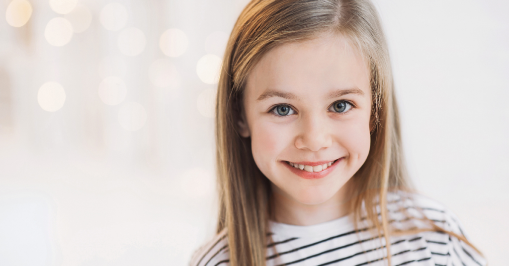 little girl smiles after using a safe mouthwash for kids