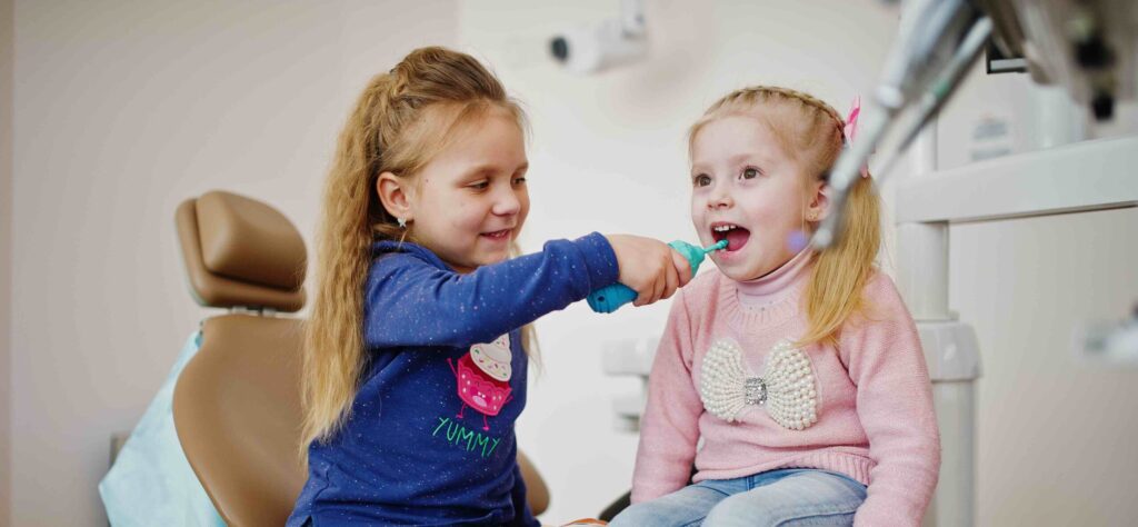 Two cutie little baby girls at dentist chair. Children dental.